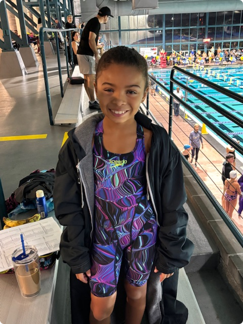 Young swimmer in jacket at pool venue